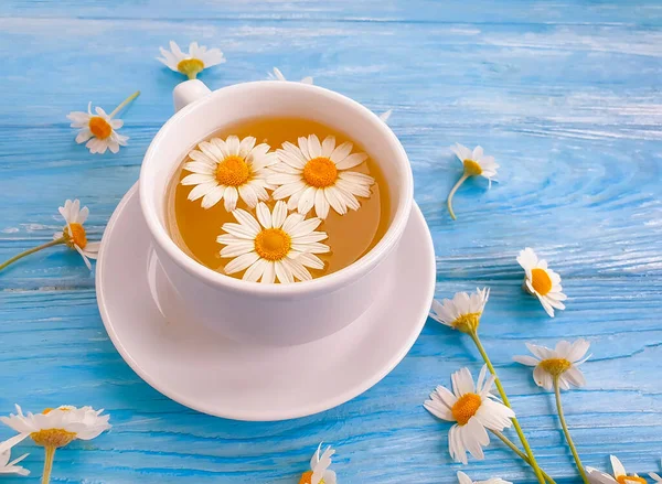 Ahşap zemin üzerinde papatya çiçeği çayı