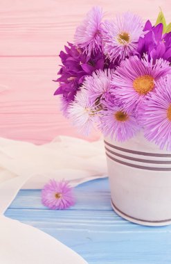 Ahşap zemin üzerinde vazo çiçeği kasımpatısı