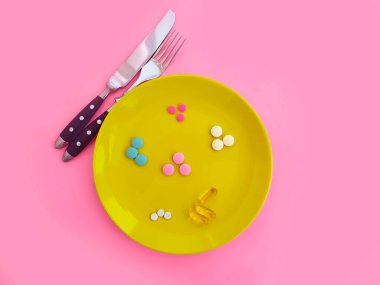 Renkli bir arka planda vitamin tabağı