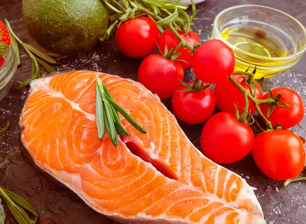 Kırmızı balık bifteği, beton arka planda domates.
