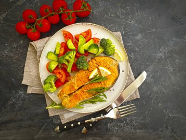 Tabakta kızarmış somon, çimentoda domates.