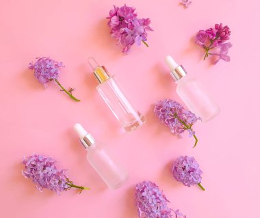 Renkli arkaplanda serum kozmetik çiçeği leylağı