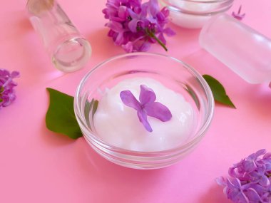 Renkli arkaplanda serum kozmetik çiçeği leylağı