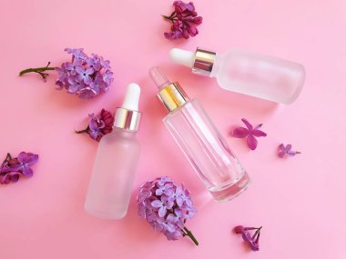 Renkli arkaplanda serum kozmetik çiçeği leylağı