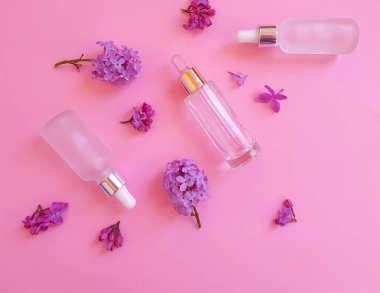 Renkli arkaplanda serum kozmetik çiçeği leylağı