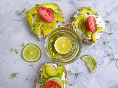 Beton arka planda avokado limonlu sandviç.