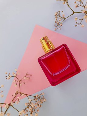 Renkli arka planda bir şişe parfümü çiçeği.