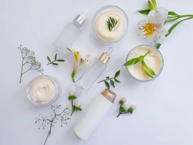 Kozmetik krem, beyaz arka planda çiçek.