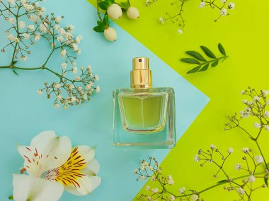 Renkli arka planda şişe parfümü çiçeği