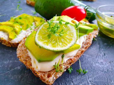 Beton arka planda avokado limonlu sandviç.