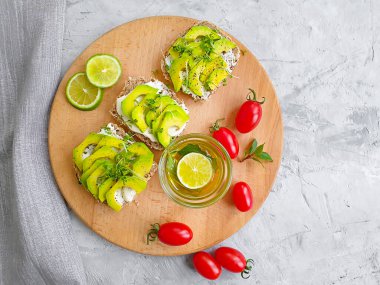 Beton arka planda avokado limonlu sandviç.