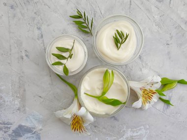 Kozmetik krem, çimento arka planda çiçek