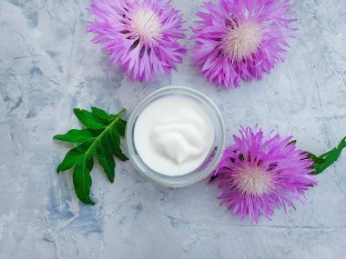 Beton zemin üzerinde krem kozmetik çiçek