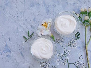 Kozmetik krem, çimento arka planda çiçek