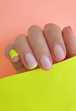  Kadın eli. Renkli arka planda güzel bir manikür.