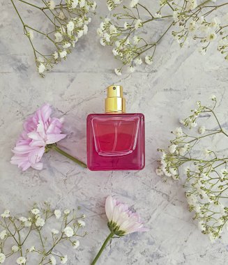 Beton bir arka planda şişe parfümü çiçeği