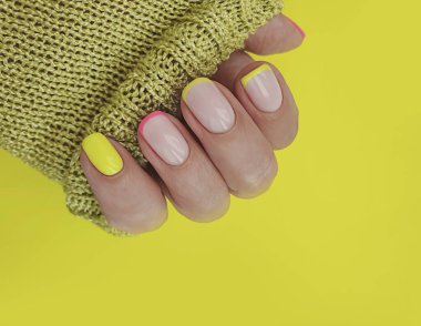  Kadın eli. Renkli arka planda güzel bir manikür.