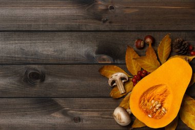 Mantarlı, fındıklı balkabağı ve koyu ahşap arka planda sonbahar yaprakları..