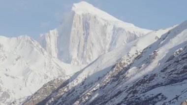 A breathtaking view of a snow-capped mountain in the Karakoram Range, Pakistan, captured during early morning with clear skies.