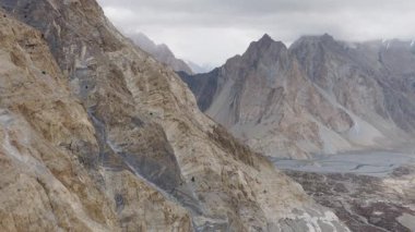 Aerial view of a remote mountain valley in Pakistan, highlighting the dramatic landscape and serene river.