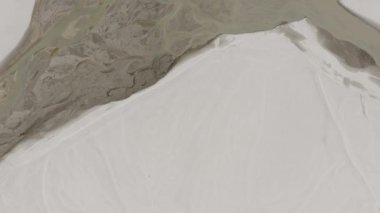 Aerial view of a braided river system in Pakistan, highlighting the intricate patterns of water flow and the surrounding arid landscape.