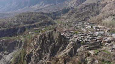 Aerial view of a remote village nestled in the mountains of Pakistan, showcasing traditional architecture and rugged terrain.