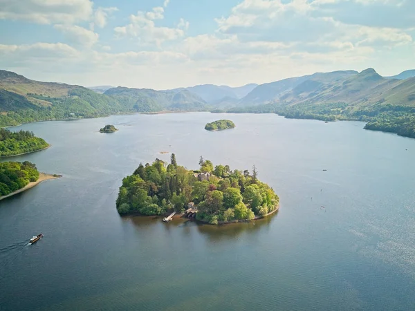 Bereketli yemyeşil bir adanın havadan görünüşü, sakin bir göl ve dağlarla çevrili..