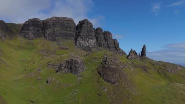 Storr 'un Yaşlı Adamı, İskoçya' nın Skye Adası, Storr 'un Yaşlı Adamı' nın mavi gökyüzünün altında güzel mavi gökyüzü altında çimenli yamaçları olan ünlü bir kaya oluşumunun insansız hava aracı çekimi..
