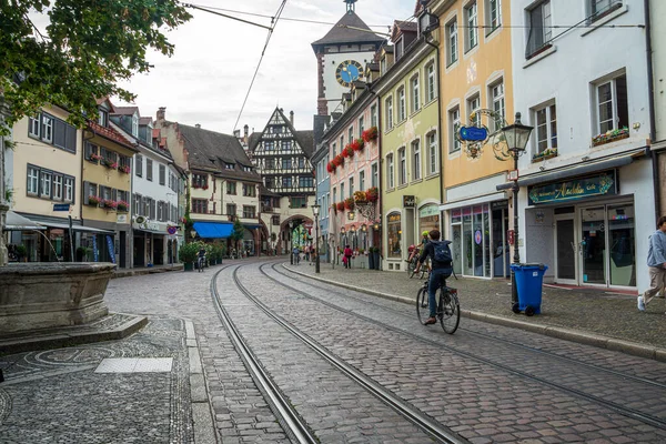 Freiburgs Martinstor 'da sakin bir sabah sahnesi, ikonik kule, tramvay hattı ve hayat dolu eski kasaba atmosferi..