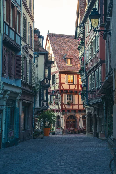 Colmar 'ın büyüleyici kaldırım taşı sokakları güneşin altında parlıyor, renkli perdeler ve geleneksel Alsas mimarisi ile çevrili..