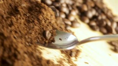 Kaşık, kahve çekirdeğine karşı öğütülmüş kahveyi topluyor. Yüksek kaliteli FullHD görüntüler