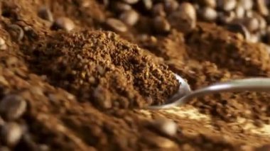 Kaşık, kahve çekirdeğine karşı öğütülmüş kahveyi topluyor. Yüksek kaliteli FullHD görüntüler