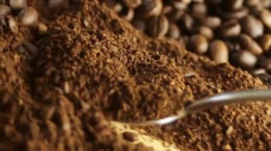 Kaşık, kahve çekirdeğine karşı öğütülmüş kahveyi topluyor. Yüksek kaliteli FullHD görüntüler