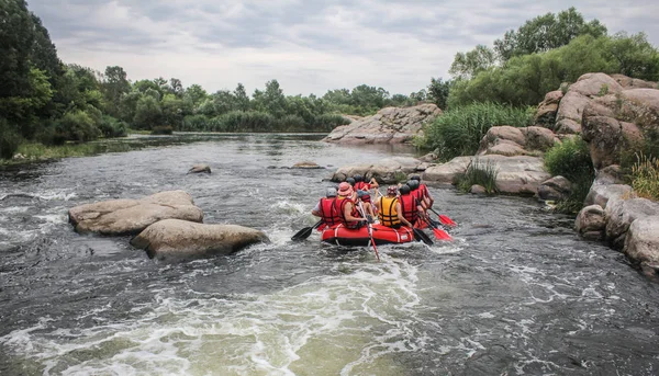 Kadın ve erkek grup, faaliyet Nehri'nde rafting suyun keyfini çıkarın. Aile tatil günlerinde rafting