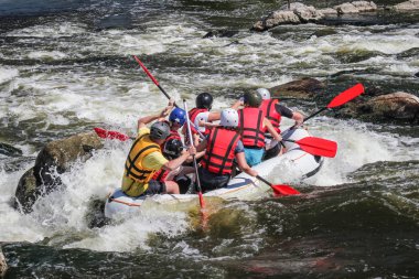 Kadın ve erkek grup, faaliyet Nehri'nde rafting suyun keyfini çıkarın. Aşırı salın