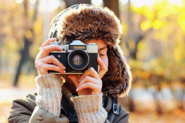 Genç kadın sonbahar parkta fotoğraf çekmek. Kavramı kız fotoğrafçı