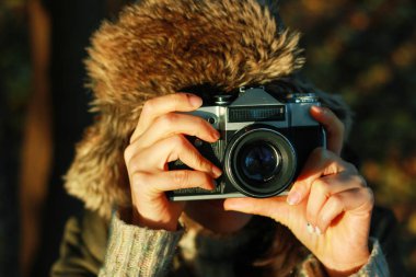 Genç kadın sonbahar parkta fotoğraf çekmek. Kavramı kız fotoğrafçı