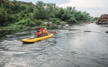 Arkadan görünüm. İki adam su aktivitesi Nehri'nde rafting tadını çıkarın. Aile tatil günlerinde rafting