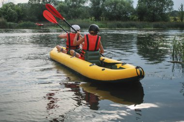 Arkadan görünüm. İki adam su aktivitesi Nehri'nde rafting tadını çıkarın. Aile tatil günlerinde rafting
