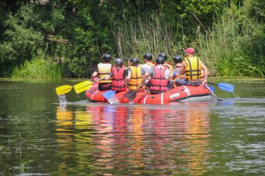 Kadın ve erkek grup, faaliyet Nehri'nde rafting suyun keyfini çıkarın. Aile tatil günlerinde rafting 