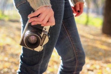 Genç fotoğrafçı ve hazır fotoğraf çekmek için elinde vintage fotoğraf makinesi