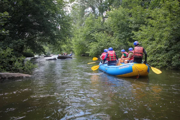 Myhiya / Ukrayna - 10 Temmuz 2018: turist orman yoluyla Nehri boyunca bir sal üzerinde rafting bir rehber olan bir grup. Pivdennyi Buh nehirde rafting