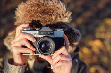 Genç kadın sonbahar parkta fotoğraf çekmek. Kavramı kız fotoğrafçı