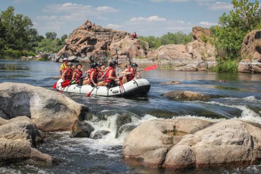 Myhiya / Ukrayna - 24 Haziran 2018: Grup Kılavuzu whitewater rafting ve nehir üzerinde turistik, aşırı ve eğlenceli spor kürek ile mutlu insan. Pivdennyi Buh nehirde rafting