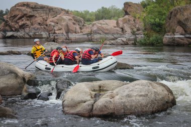 Myhiya / Ukrayna - 24 Haziran 2018: Grup Kılavuzu whitewater rafting ve nehir üzerinde turistik, aşırı ve eğlenceli spor kürek ile mutlu insan. Pivdennyi Buh nehirde rafting