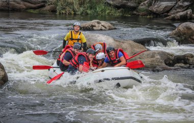 Myhiya / Ukrayna - 24 Haziran 2018: Grup Kılavuzu whitewater rafting ve nehir üzerinde turistik, aşırı ve eğlenceli spor kürek ile mutlu insan. Pivdennyi Buh nehirde rafting