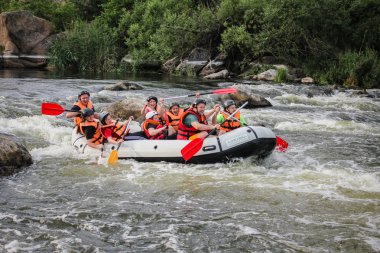 Myhiya / Ukrayna - 26 Haziran 2018: Grup Kılavuzu whitewater rafting ve nehir üzerinde turistik, aşırı ve eğlenceli spor kürek ile mutlu insan. Pivdennyi Buh nehirde rafting