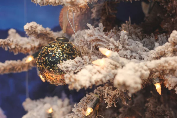 Close-up of toys on the Christmas tree. Artificial gold Christmas tree and snow — Stock Photo, Image