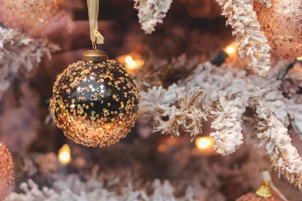 Close-up van speelgoed op de kerstboom. Kunstmatige gouden kerstboom en sneeuw — Stockfoto
