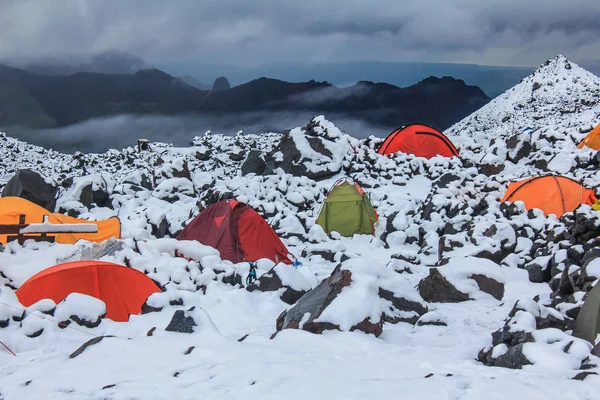 colorful tents in the snow. Climbers wait out bad weather in tents. Base camp on the northern slope of Elbru